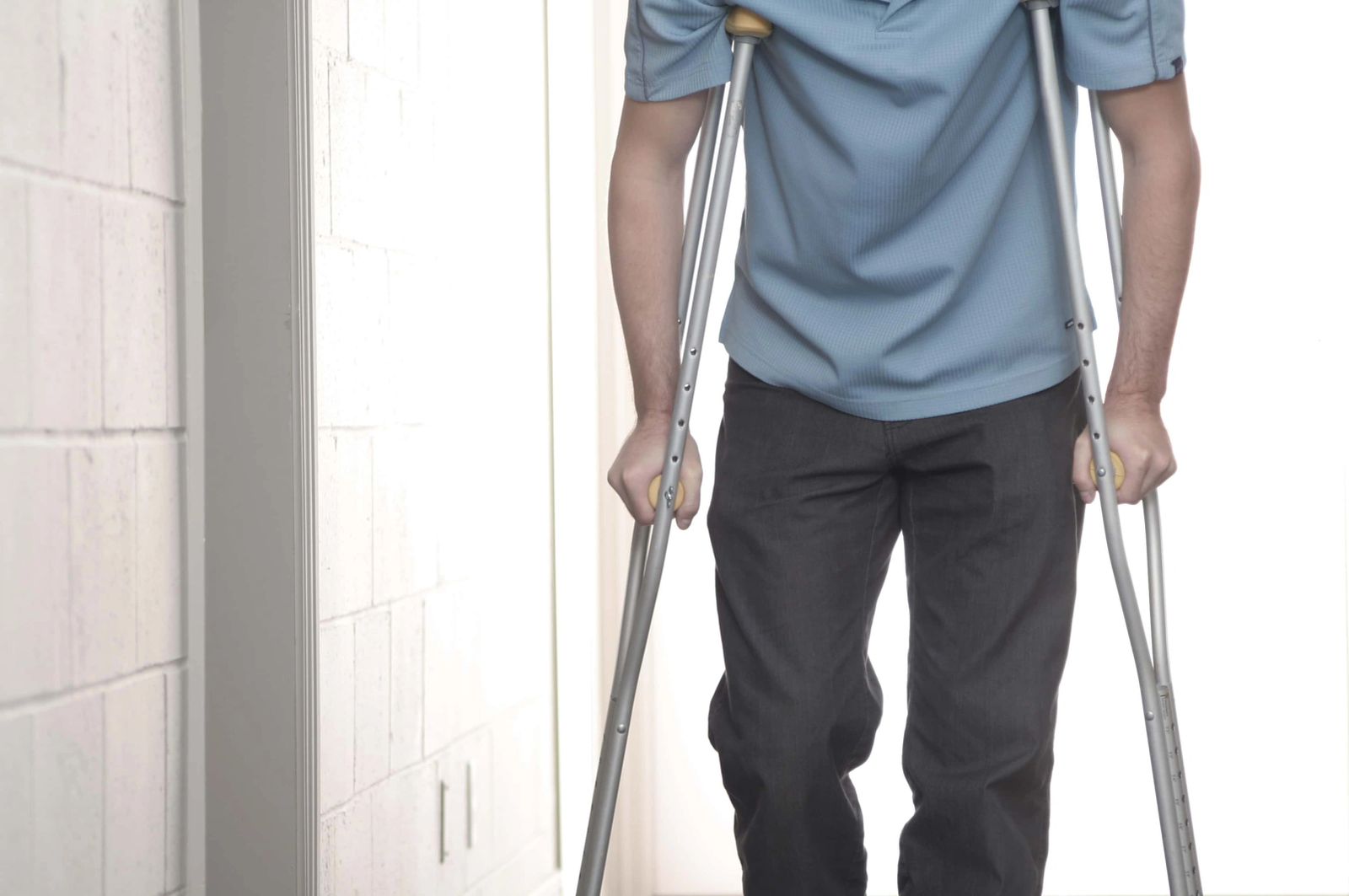 A person walking with the aid of crutches