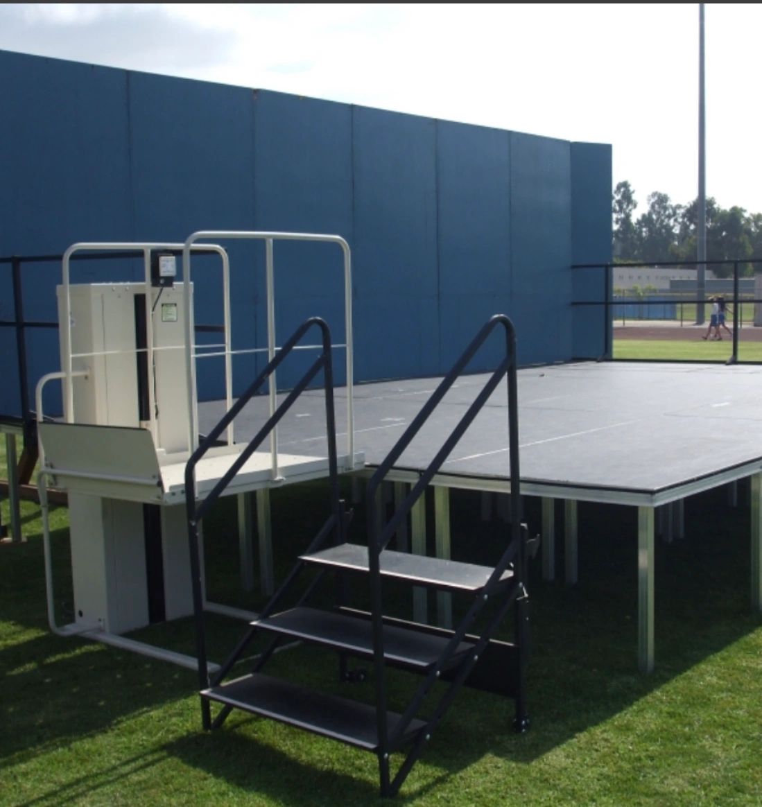 An accessibility lift installed next to a stage in an auditorium